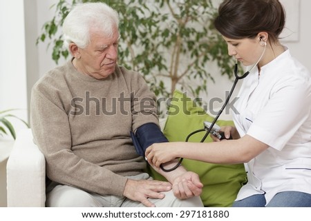Doctor measuring blood pressure of elder man