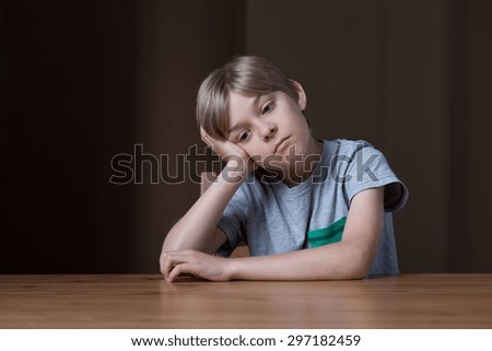 Picture of bored small boy propping up head with hand
