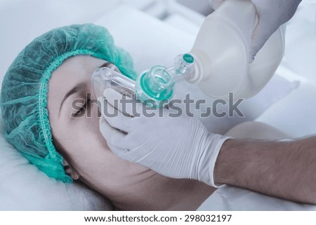 Unconscious young woman lying in oxygen mask