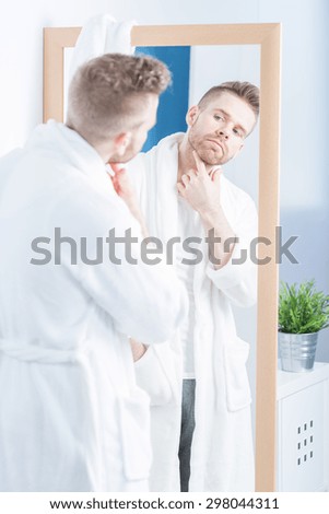 Pretty self-centered man admiring himself in the mirror