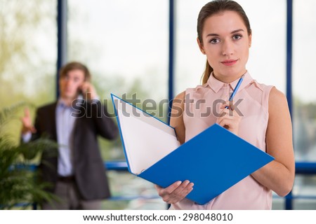 Beauty female office worker holding blue folder