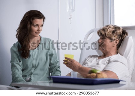 Older sick woman eating breakfast at hospital