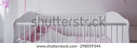 Close-up of white crib in baby room