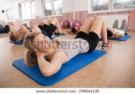Woman training her stomach muscles in fitness club