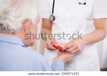 Elderly man getting medications prescribed by doctor