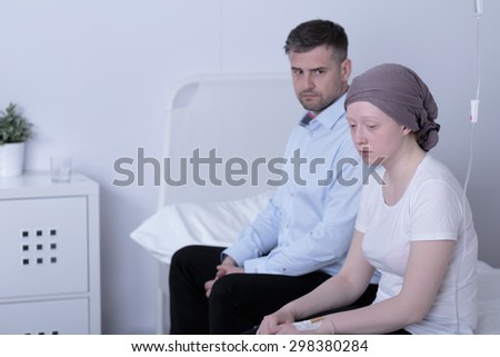 Worried girl with cancer and her helpful loving dad