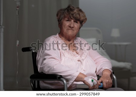 Injured sad elderly woman on wheelchair in hospital