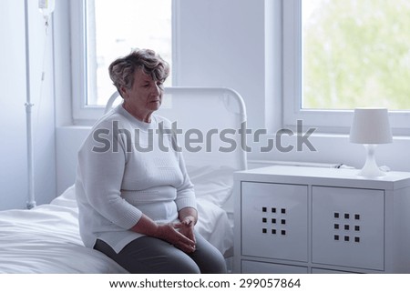 Sad older woman left alone in hospital