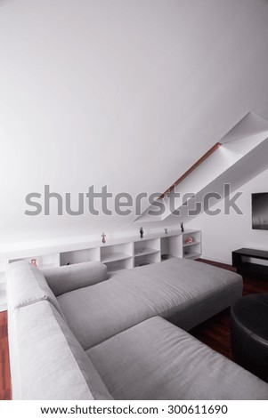 Comfortable sofa in attic room in modern residence