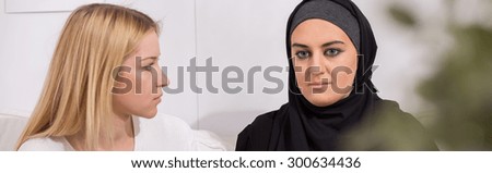 Worried muslim woman with problem and her helpful friend