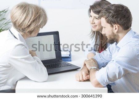 Doctor and young marriage looking at laptop screen