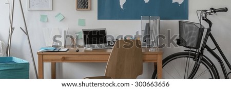 Panorama of bike standing beside wooden desk in cosy room
