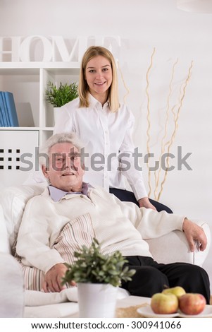Care assistant and older man posing to picture