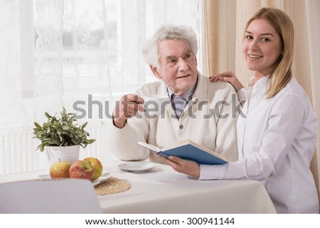 Grandfather and granddaughter drinking coffee and reading book