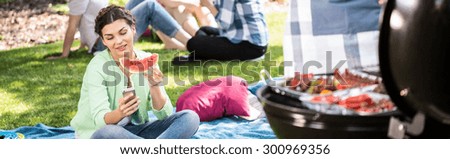 Banner of young woman eating watermelon during outdoor party