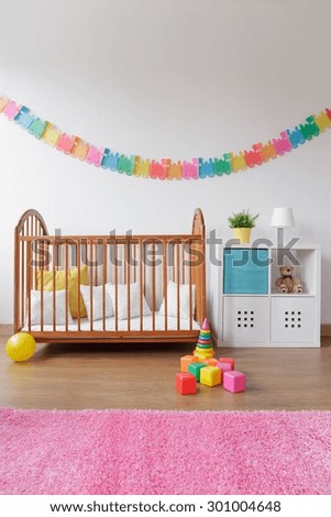 Photo of babygirl contemporary bedroom with wooden crib