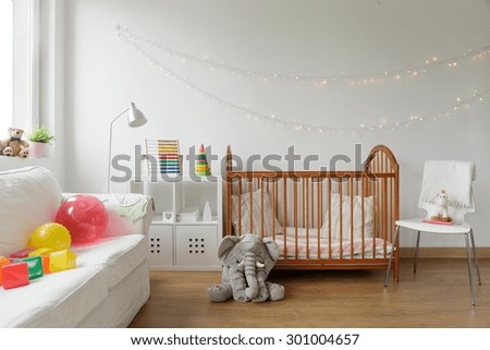 Photo of white and cosy newborn room interior