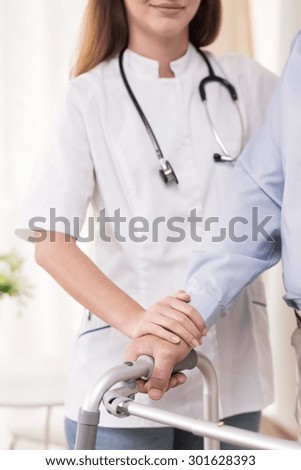 Close-up of doctor assisting disabled elder man