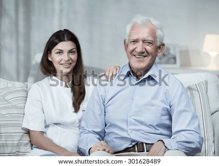 Nurse and senior man sitting on the sofa