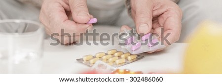 Close-up of ill person taking pink pills