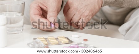 Ill person taking medicine for hypertension - panorama