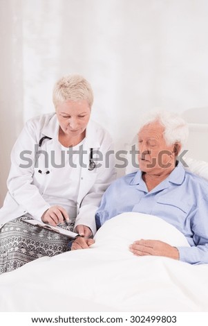 Photo of female doctor interviewing senior patient before operation