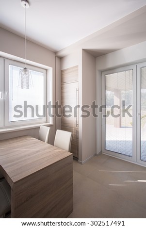 Modern furnished dining space with built-in fridge with wooden door