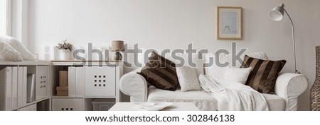Panorama of comfortable white double sofa in modern living room