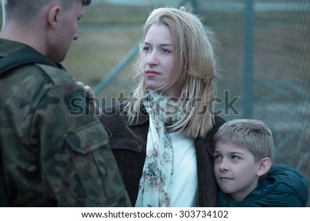 Military soldier saying goodbye to wife and son