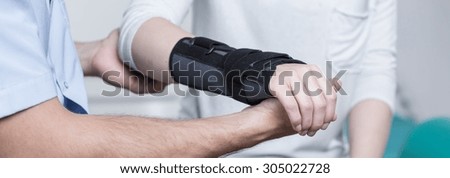 Woman with dislocated wrist in stabilizer is consulting doctor