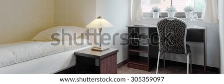 Single bed room in hotel with bed and desk