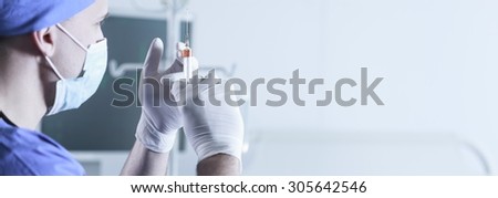 Surgeon holding a syringe and ready to make an injection