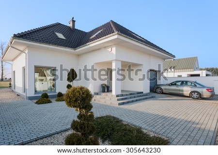 Big white residence with garage for new silver car