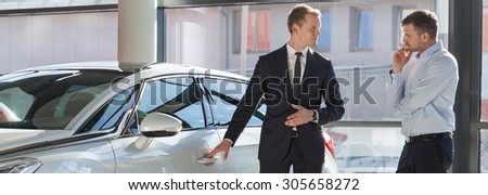 Car dealer selling modern expensive car to a client