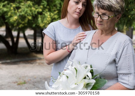 Picture of caring granddaughter supporting her sad grandma