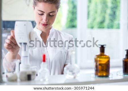 Young female lab technician doing chemistry experiment
