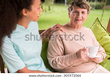 Caring nurse and elder woman in the garden