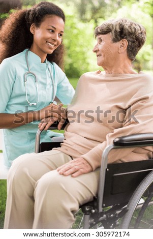Disabled woman and caring doctor in the garden