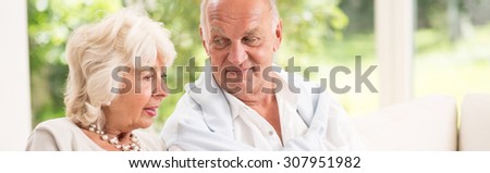 Elder couple is sitting together on the couch