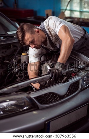 Picture of professional car technician during labor in garage