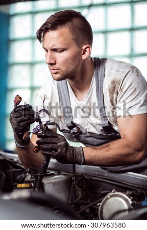Portrait of focused automobile repair shop worker diagnosing problem