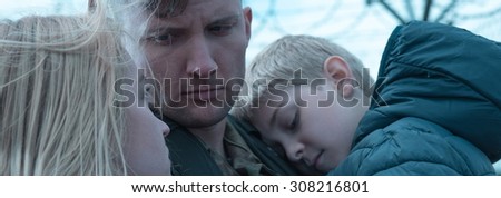 Young soldier is saying goodbye to his family