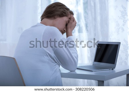 Photo of young cyber violence victim sitting at computer