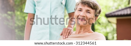 Panorama of happy elderly woman having private medical care