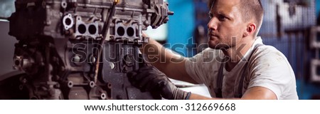 Repairer fixing car engine in the workshop
