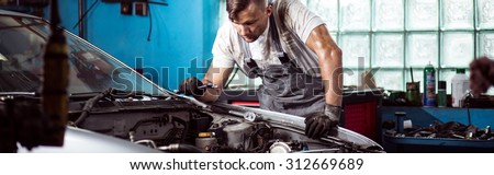Fixing car engine in automobile repair shop