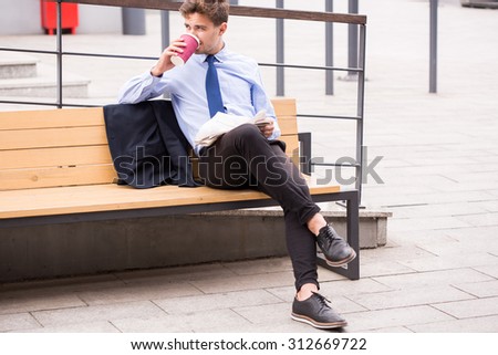 Image of elegant commuter drinking coffee while waiting for bus