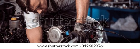 Close-up of motor mechanic repairing car engine