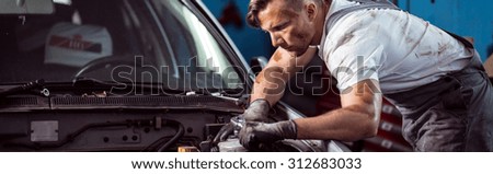 Young auto mechanic working in car repair shop