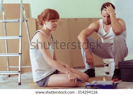 Image of despair young couple renovating house